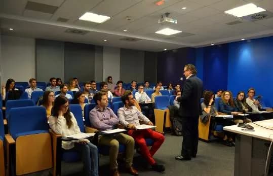 Sesión de IDESIE en un auditorio con alumnos y ponente
